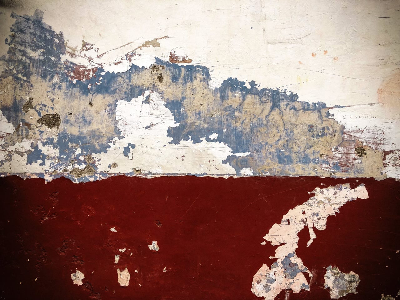 Cream plaster peeling off a maroon base