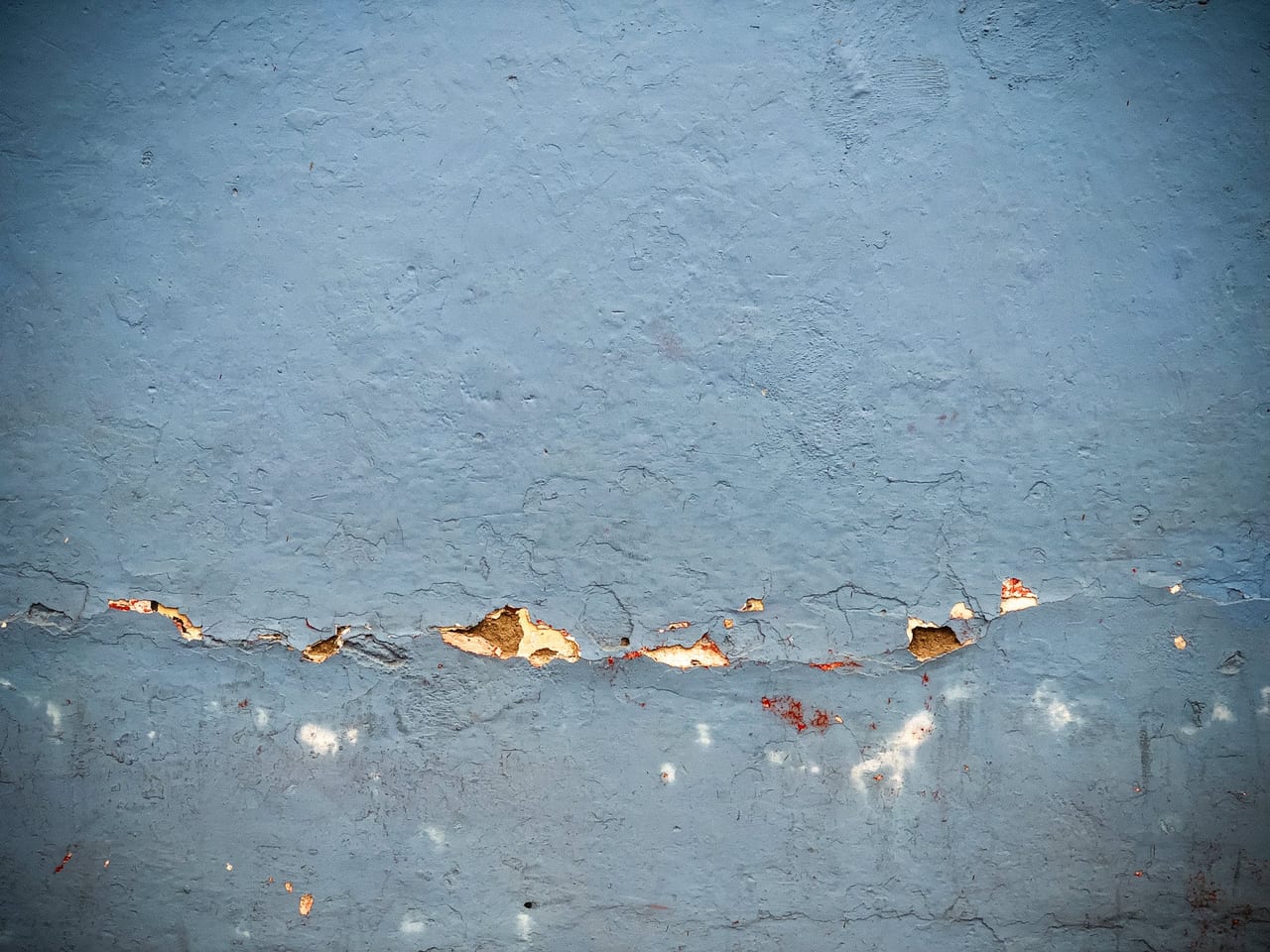 A crack running through a teal wall
