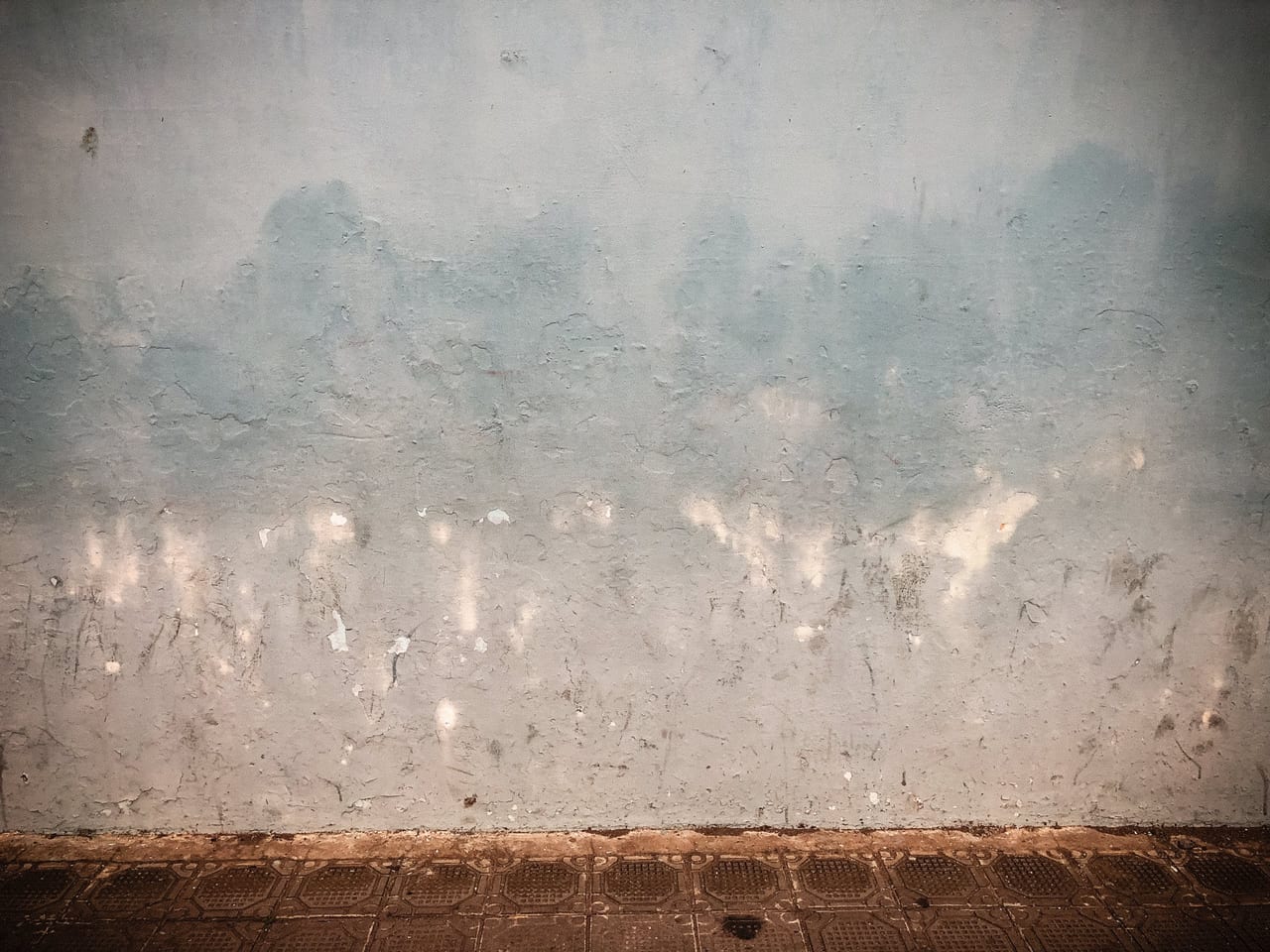 Grey-green paint fading above a red stripe