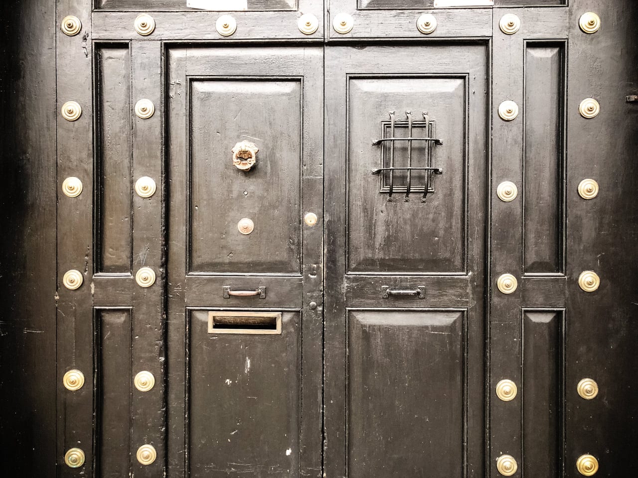 A black door studded with brass