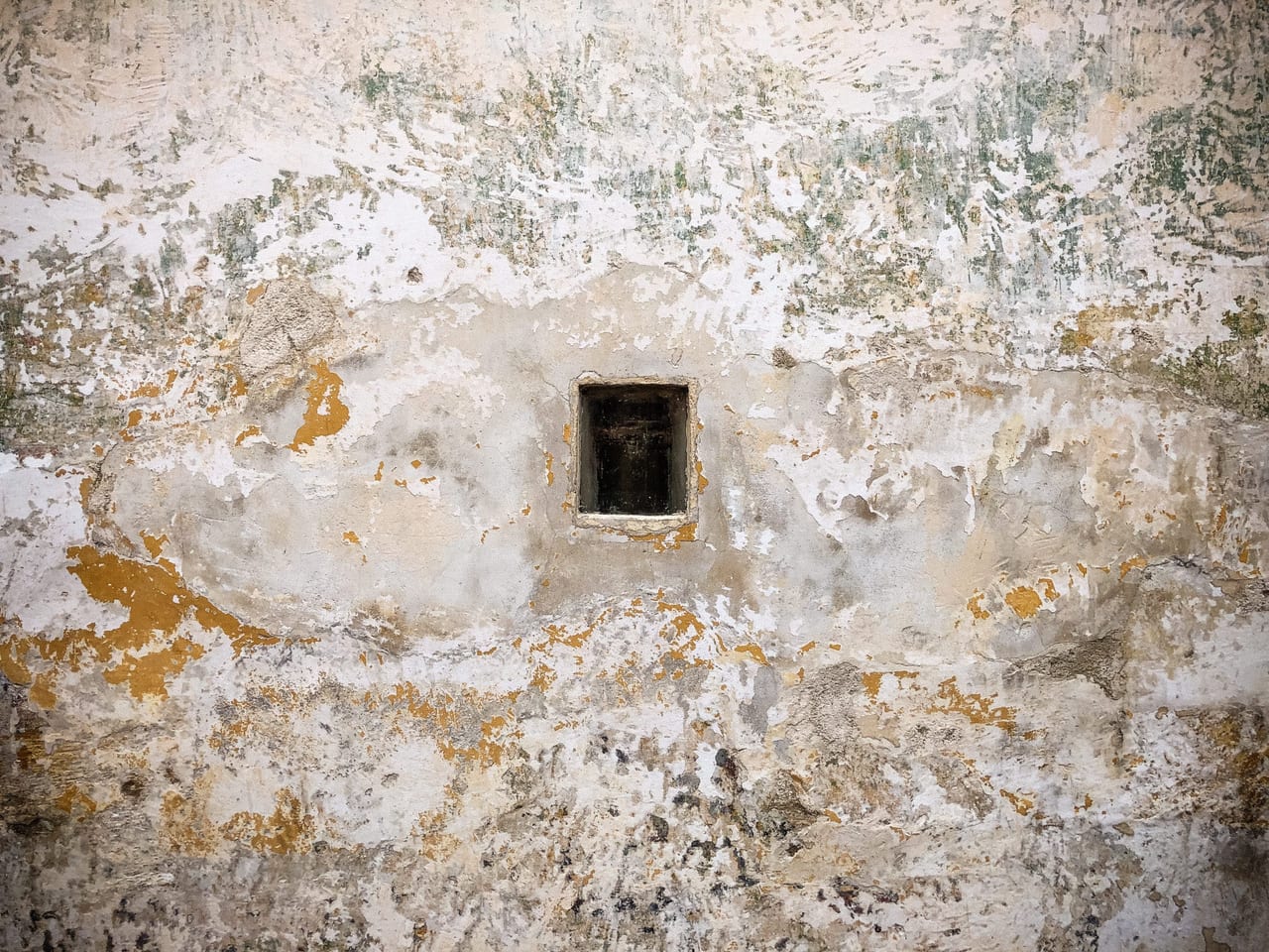 A small dark opening in a grey wall
