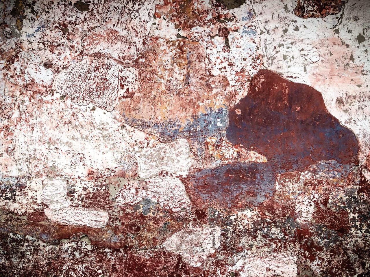 Plaster crumbling into rust and pink