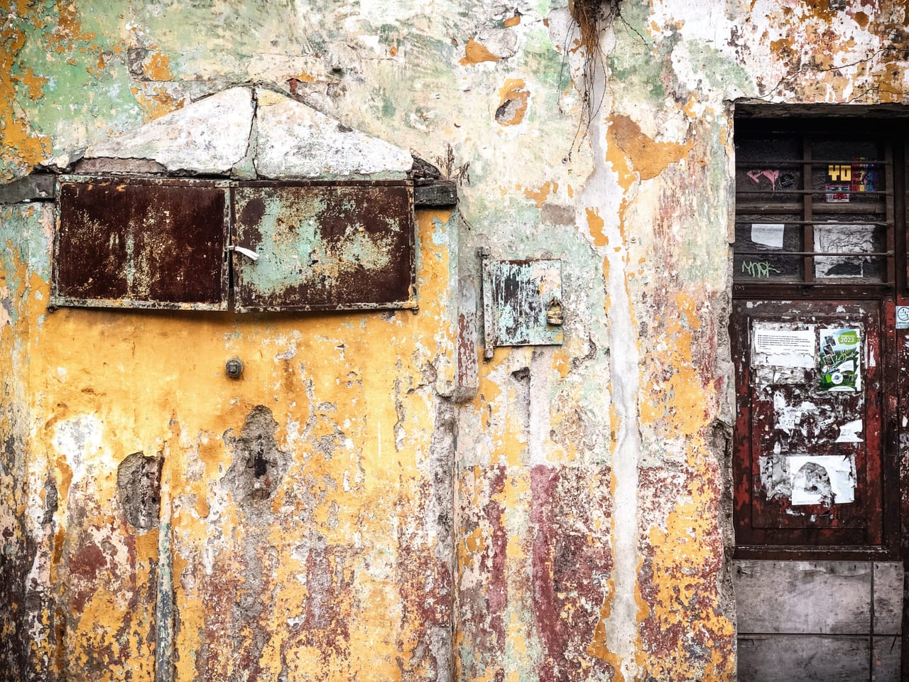 A mailbox and a meter on a yellow wall